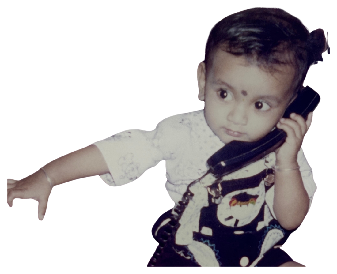 Harsh Naik as a baby holding a phone to his ear